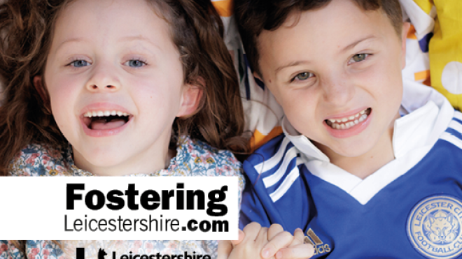 Two young children holding hands. A girl with brown wavy hair and a boy wearing a Leicester City top 