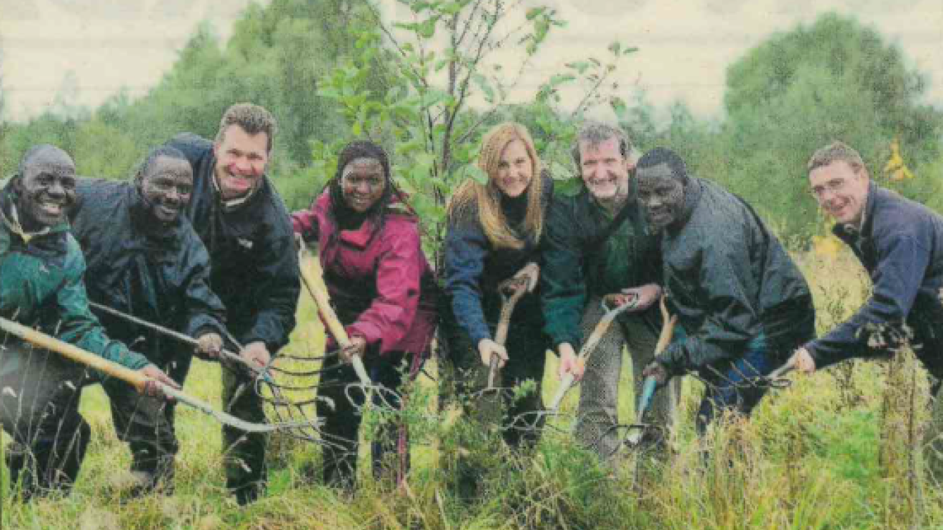 Dale with Ugandan rangers helping plant a tree