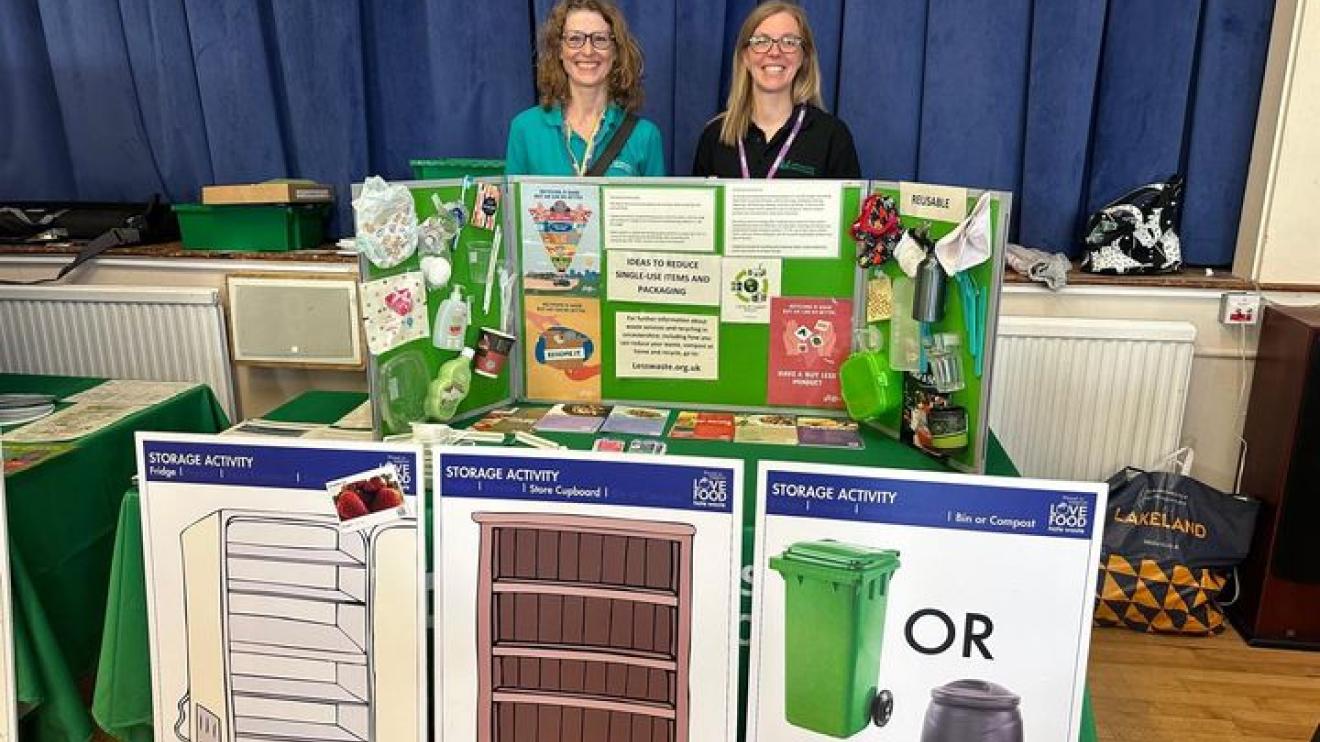 Two colleagues sit behind a desk and promote environment action volunteering