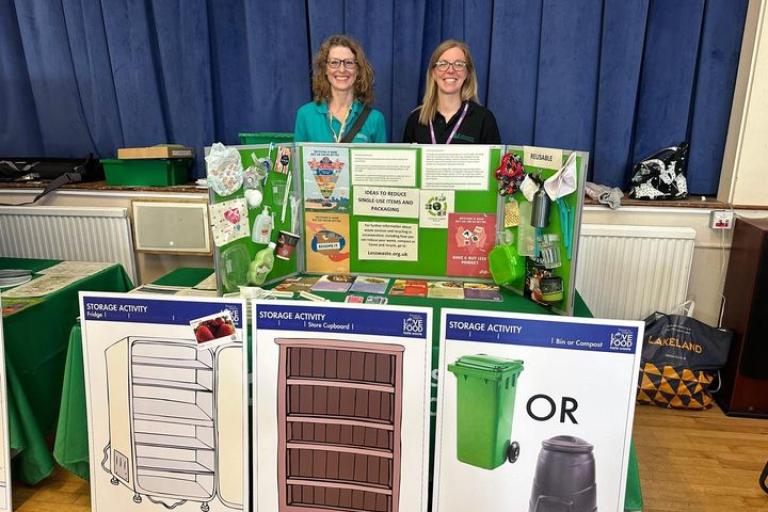 Two colleagues sit behind a desk and promote environment action volunteering