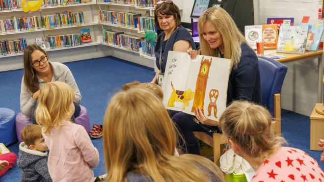 Staff members in a reading group with young children and their parents