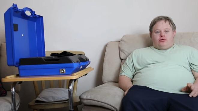 Picture of Chris with his at-home technology stored in a blue box on his right-hand side