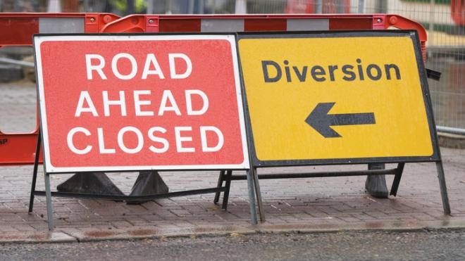 Two road signs reading road ahead closed and diversion 