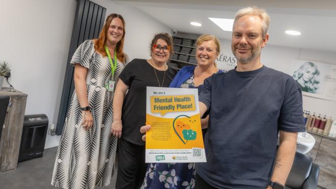 members of fox hair salon with a representative of the county council and the cabinet member, holding a poster saying "we're a mental health friendly place."