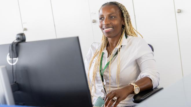 Leicestershire County Council staff facing a monitor and smiling