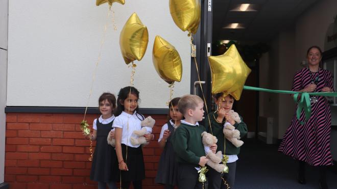 Wellington Place pupils pose with gold star shaped balloons