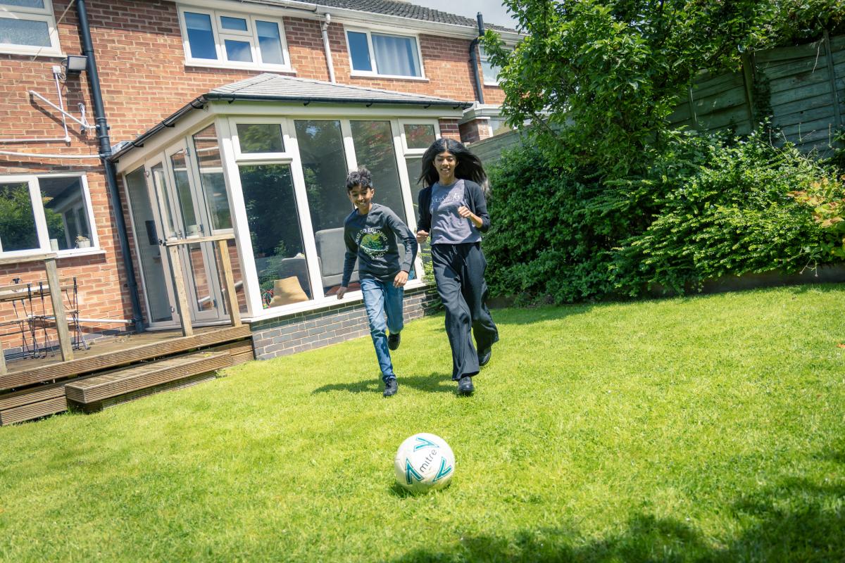 two children playing football in garden