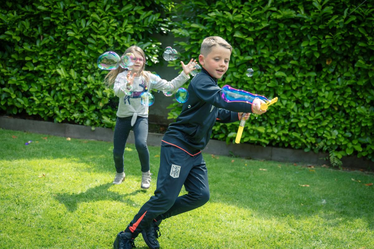 children playing in garden with bubbles