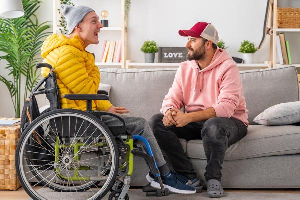 Young man having a good time with his carer in a home environment